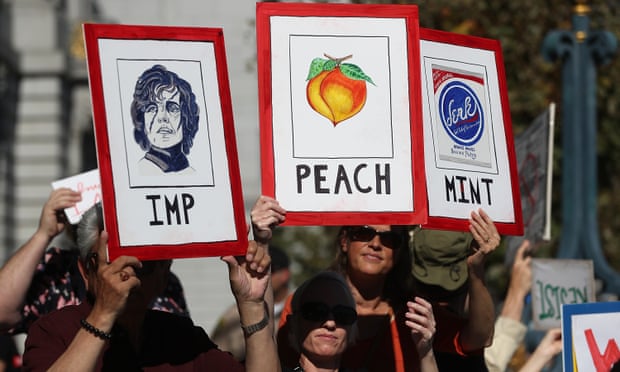 Attendees at a rally addressed by Steyer hold signs calling for the impeachment of Donald Trump.
