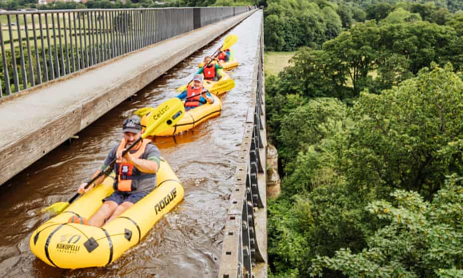 Jason leads the group of four, paddling individual  rafts, across the ‘stream in the sky’ on top of a viaduct.