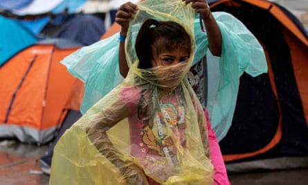 A migrant girl, part of a caravan from Central America trying to reach the US, wears a raincoat at a temporary shelter in Tijuana, Mexico.