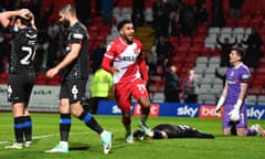 Jamie Reid celebrates putting Stevenage 4-3 up, with devastated Tranmere players who had just pulled level