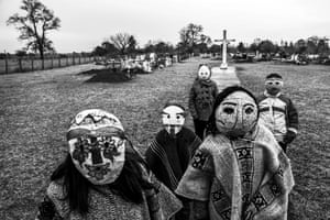 Children wear traditional Ngillatun masks in a Mapuche cemetery. Maihue, Los Ríos, Chile, 28 July 2019