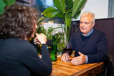 A woman and man facing each other across a restaurant table