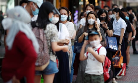 Chinese tourists buy protective masks at a supermarket in Bangkok