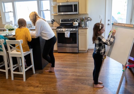 A mother assists her daughters with homeschooling in New Rochelle, New York.