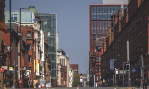 A woman walks across an empty Deansgate in central Manchester in late April.