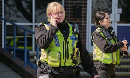 Sgt Catherine Cawood in bullet-proof vest on phone, played by Sarah Lancashire