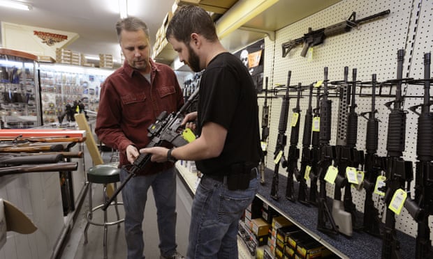 A sales representative shows a customer an an AR-15-style rifle.