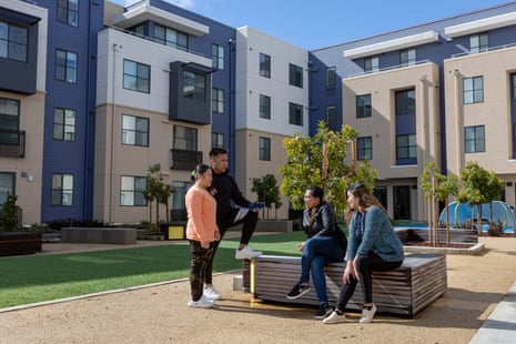 Four people talking in the central courtyard of an apartment building.