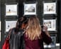 Two women looking at houses for sale at an estate agent's window