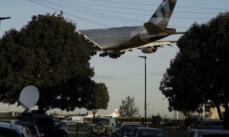 A police vehicle on patrol near Heathrow airport in London, as a plane comes in to land.