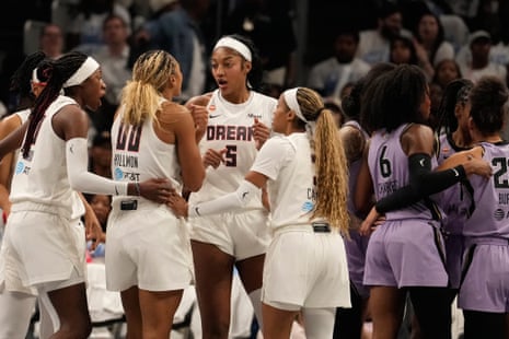 Atlanta Dream players, including Angel Reese, huddle and talk intensely on the court