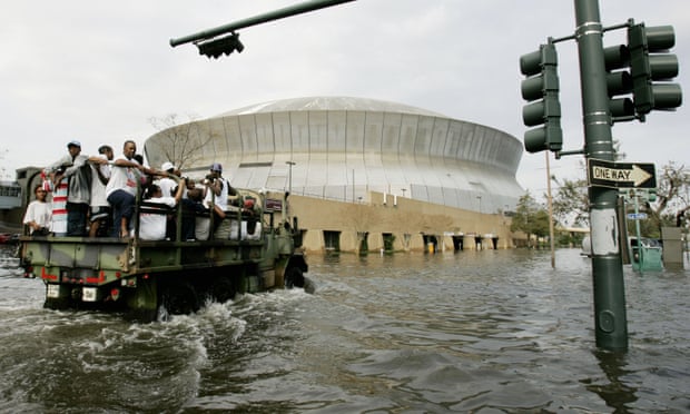 National Guard trucks haul residents through floodwaters to the Superdome.
