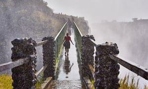 A visitor crosses a bridge at the Victoria Falls.