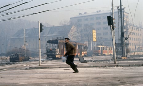 A civilian runs through the streets of Sarajevo, where Richard Holbrooke worked for the Clinton government