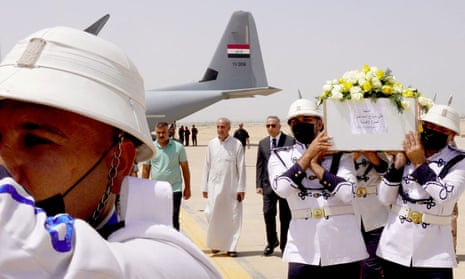 Honour guards carry the coffins of victims of the attack near Zakho, at Baghdad airport