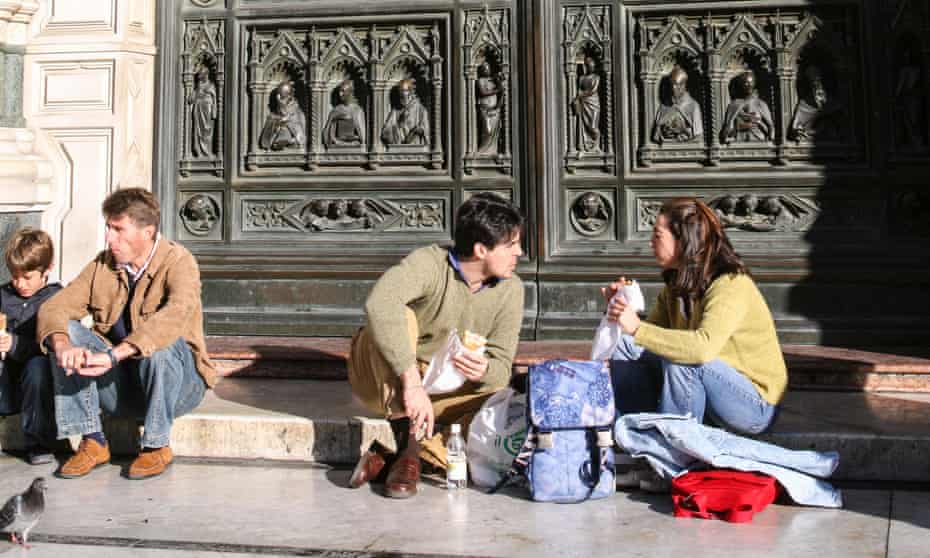 Tourists eating in front of the cathedral in Florence.
