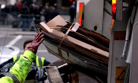 Rubbish collectors are seen emptying bins into a lorry