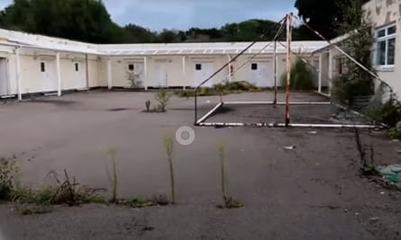 Bexhill courtyard with overgrown shrubs and rusted metal frame