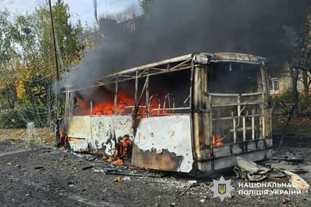 The bus on fire after the Russian missile strike, with the anti-drone nets in view.