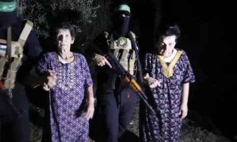 A screen grab from a video shows Israeli hostages Yocheved Lifshitz and Nurit Yitzhak escorted by a member of Hamas' Al-Qassam Brigades.