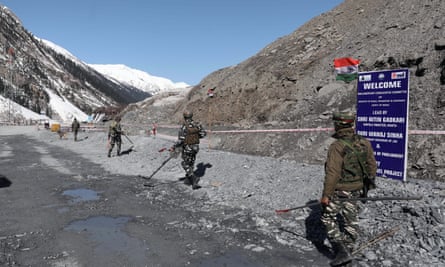 Indian security forces accompanied by a sniffer dog clear an area near the Zojila tunnel.