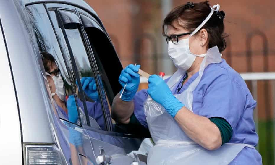 A member of the public is swabbed at a drive through Coronavirus testing site
