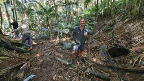 Sam Burridge smiles at the camera as he take a break from installing sprinklers at the release site for the snails, a ‘beautiful valley surrounded by palm trees’.
