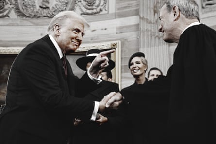 a man shakes the hand of another man and points at him while smiling