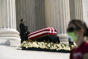 Mourners walk by Ginsburg’s flag-draped casket.