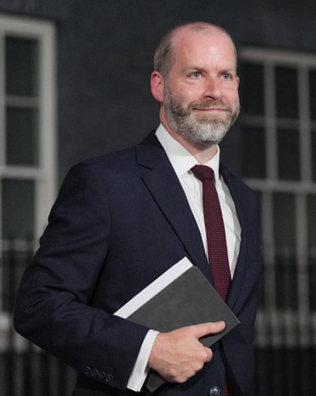 Jonathan Reynolds stands outside Downing Street with a black notebook under his arm. He is in his mid-40s with close-cropped, receding grey hair and a short, neat beard.