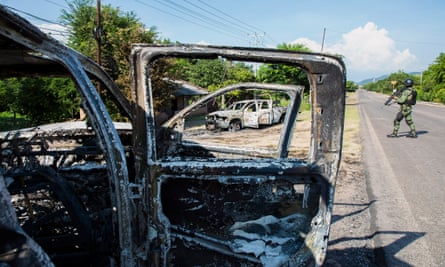 Police vehicles torched by gunmen who also killed 14 police officers in an ambush in El Aguaje village, in the municipality of Aguililla.