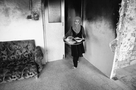 A young girl, Lama, serving food in her family’s bomb-damaged home in Mosul, Iraq.