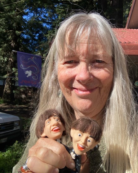 A middle-aged woman holds Paul McCartney and Ringo Starr figurines.