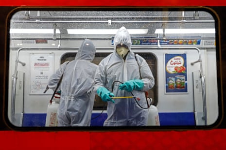 Iranian municipality workers spray disinfectant within a Tehran subway train as a precaution against COVID-19.