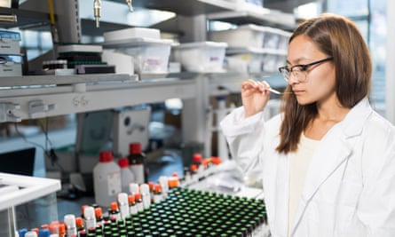 A woman sniffing a scent strip in a laboratory