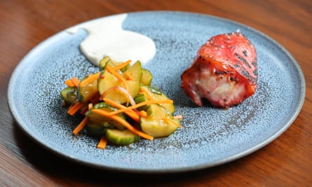 Monkfish char suey and cucumber salad on a blue round plate