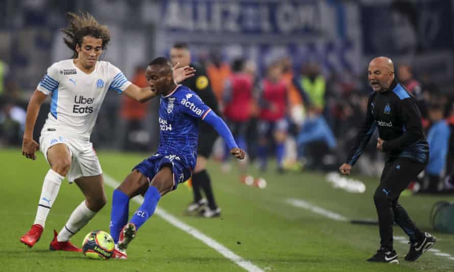 Matteo Guendouzi (left) closes down Lorient's Stephane Diarra (middle) under the watchful eye of Jorge Sampaoli.