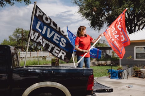 a woman installs flags on the back of a pickup truck