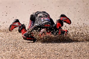 A motorcyclist crashes headfirst into the gravel after a fall