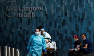 Health workers move a patient at New York University’s Langone hospital in Manhattan on Sunday.