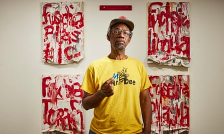 Pope.L at Modern Art gallery, 7 Bury Street, London with four of his artworks behind him