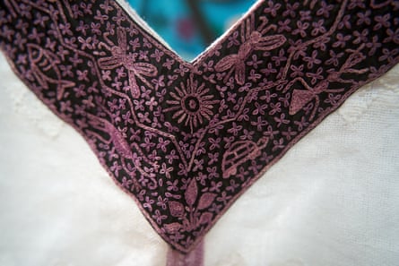 The corner of a purple, embroidered piece of cloth