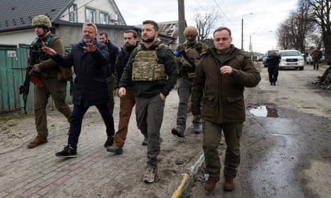 Ukraine's president, Volodymyr Zelenskiy, listens to the mayor of Bucha after Russian troops left the Ukrainian town