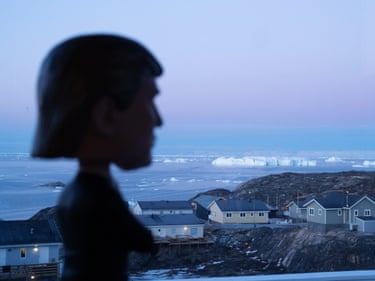 A landscape of Greenland with a silhouette of a Trump figurine in the foreground