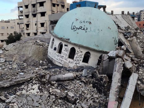 The remnants of a destroyed mosque with Hebrew text written on the side of the dome tower and Arabic text on the dome itself.
