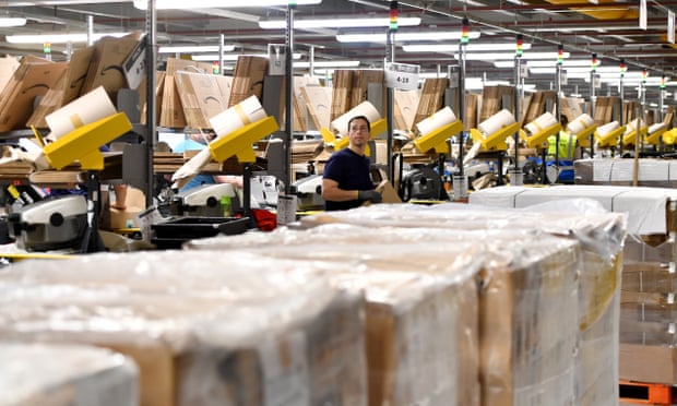A staff member packs items in the Amazon Fulfilment Centre in Altrincham, Manchester, England, 2019