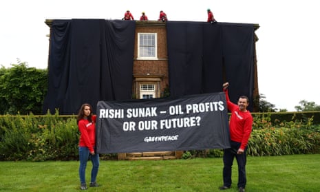 Rishi Sunak’s house covered in black fabric with two protesters holding a banner on the ground stating: Rishi Sunak - Oil Profits or Our Future?