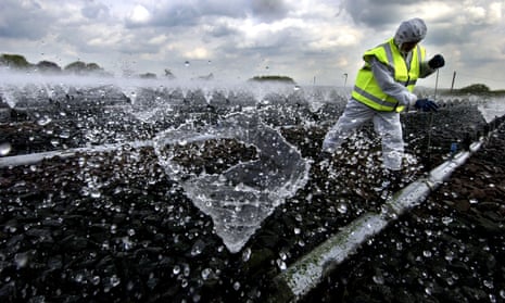 A worker carries out cleaning and maintenance work at a sewage works