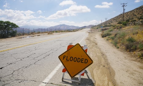 An empty road in California with a flood warning sign.