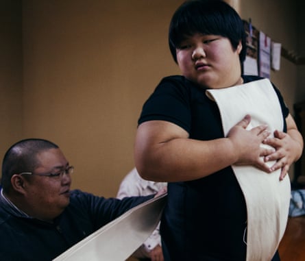 Abe-san ties the sumo belt on his daughter Nana